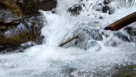 Water-cascading-over-moss-covered-rocks-in-a-mountain-stream-on-a-warm-spring-day