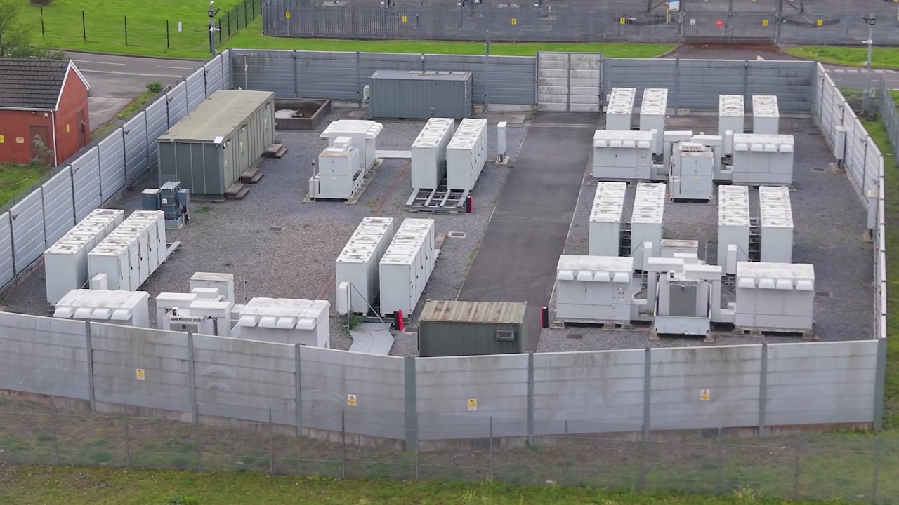 Installazione di sistema di accumulo di energia a batteria BESS agli ioni di litio. Moderna infrastruttura di energia verde, tecnologia smart grid, transizione energetica, soluzioni energetiche sostenibili. Regno Unito. Clip aerea con drone