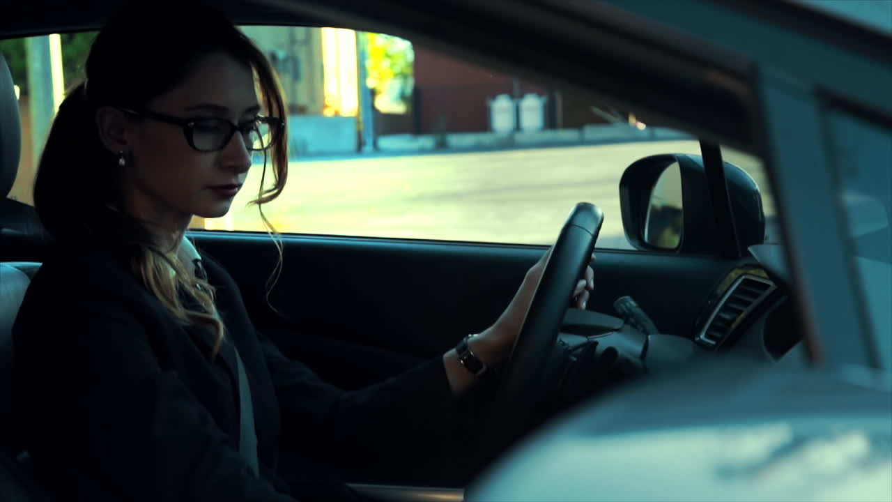 la mujer de negocios está estacionada en su coche, pone el coche en marcha y luego se va
