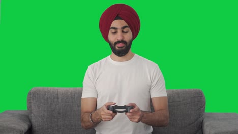 happy sikh indian man playing video games green screen