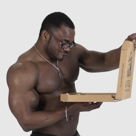 sportsman with pizza isolated in studio. fit african man opening box with pizza isolated in studio