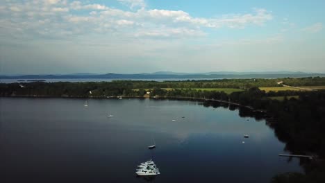 Aerial-clip-of-Lake-Ontario-and-his-beaches,-with-some-boats-sailing-or-berthed-near-the-coast