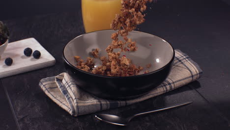 super slow motion healthy breakfast, cereal granola falling into a bowl on a table. shot with high speed camera at 420 fps