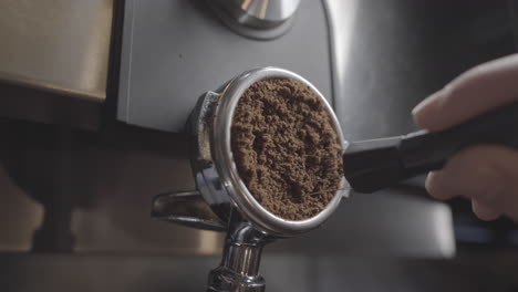 a reveal shot of ground coffee being stirred with a needle tamper in a portafilter