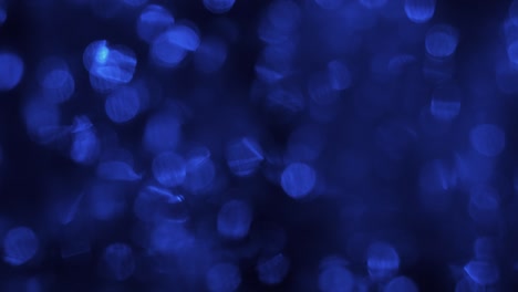 Ripple blue bokeh. Bokeh reflected in water with raindrops falling.
