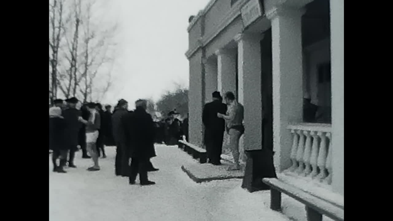 Group of People Standing in the Snow During the Soviet Era. CIRCA USSR 1970: A group of people, most likely Soviets, standing together in the snow during the cold winter.
