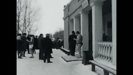 group of people standing in the snow during the soviet era. circa ussr 1970: a group of people, most likely soviets, standing together in the snow during the cold winter.