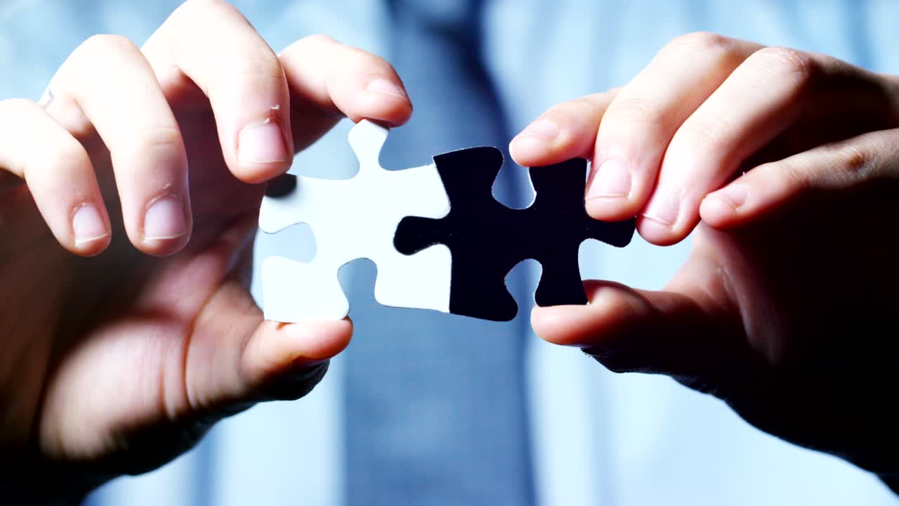 una mano completa un rompecabezas claro en blanco y negro, concepto de estrategia, trabajo en equipo y mundo financiero