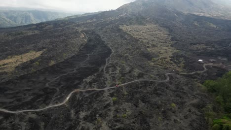 Pistas-Aéreas-De-Camiones-Conduciendo-Por-La-Carretera-A-Través-Del-Campo-De-Lava-Del-Monte-Batur