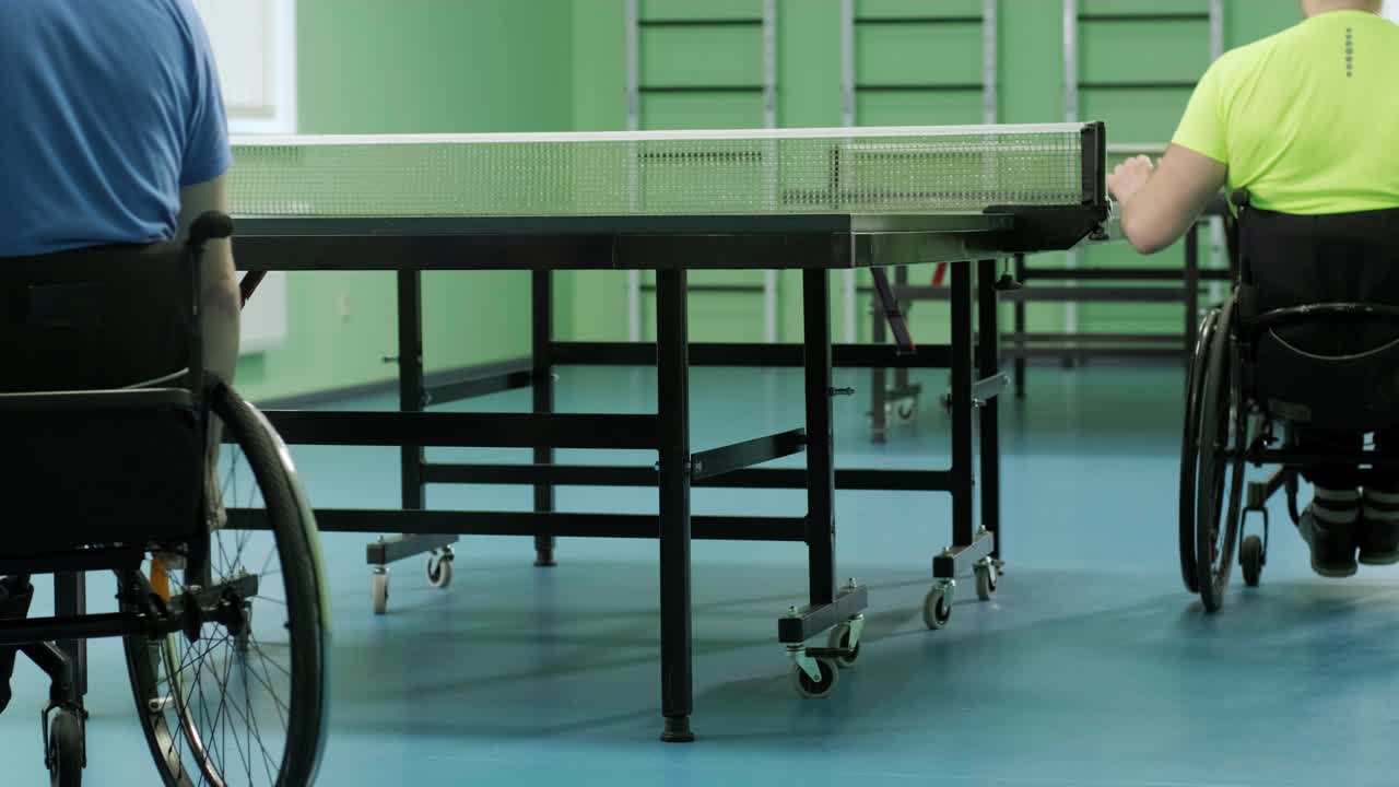 체어에 앉아 있는 남자가 핑핑을 하고, 장애인들이 탁구를 하고, 장애인의 재활, 패럴림픽 스포츠.