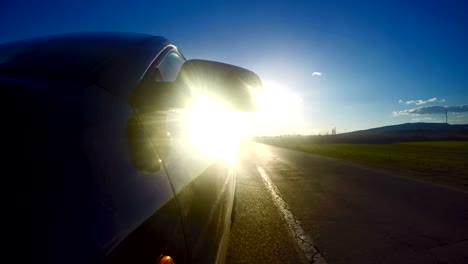 car traveling on rural road in sunset light. uhd stock video