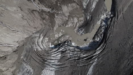Top-down-aerial-view-of-melting-Pasterze-glacier-landscape-covered-in-moraine-due-to-global-warming