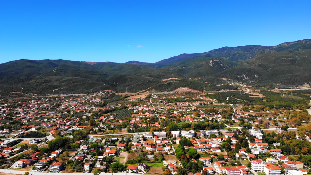 View of Asprovalta from the drone. Buildings and greenery. Green hills on the background. Greece