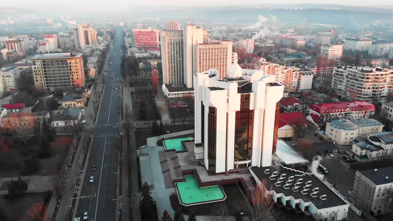 Aerial drone view of presidency building at sunrise. Warm sun, city and cars riding on background. Chisinau, Moldova