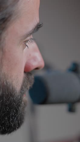 close-up profile of a bearded man speaking into a microphone