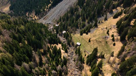 Una-Toma-Aérea-De-Seguimiento-Dinámico-Moviéndose-Alrededor-De-Las-Casas-En-La-Ladera-De-La-Montaña-En-La-Región-Italiana-De-Piemont