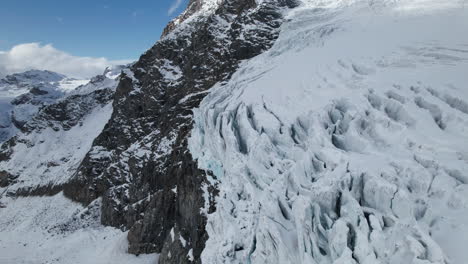 Drone-landscape-view-of-the-cracks-of-the-face-of-a-large-glacier-on-a-sunny-day-in-winter-in-the-Alps