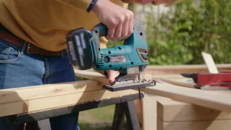 primer plano de aserrar madera con sierra de calar