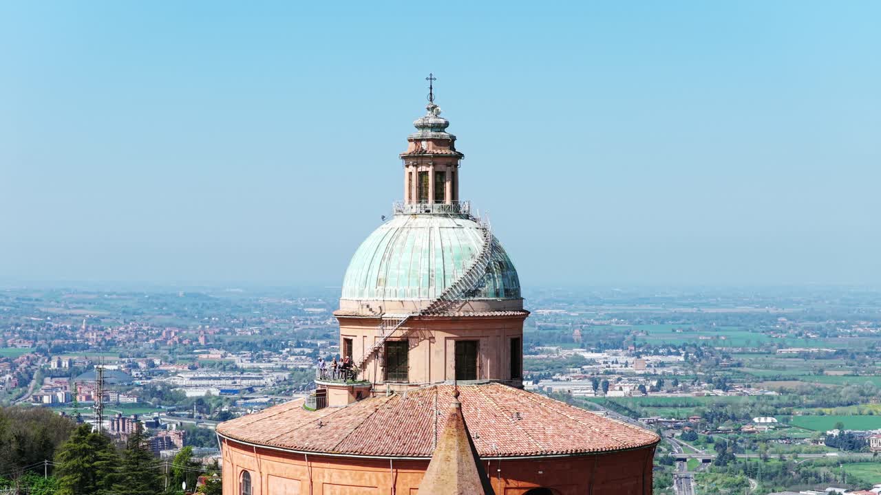 Drone orbit shot of the dome of the Sanctuary of San Luca in Bologna, Italy, revealing architectural details and panoramic views over the surrounding countryside and urban landscape
