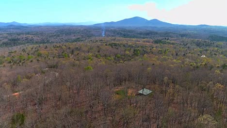 drone-flying-over-trees-heading-towards-smoke