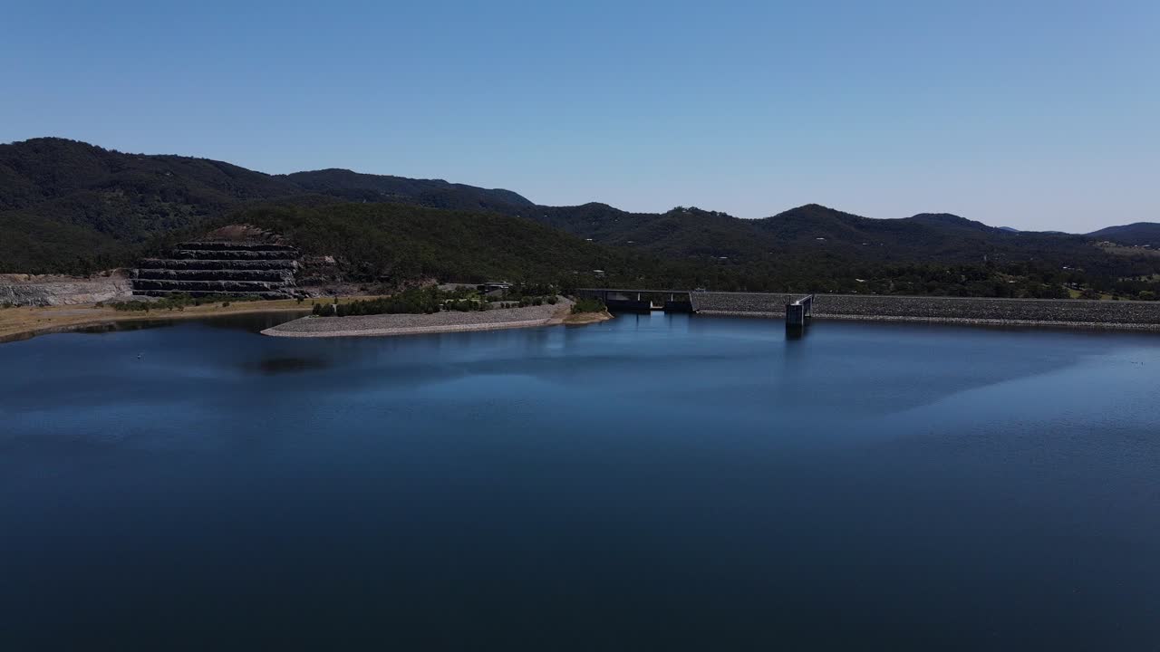 낮에 힌즈 댐의 잔잔한 물 위를 날다 - 저수지 방수로 탑 - 어드밴스타운, 골드 코스트, qld, 호주