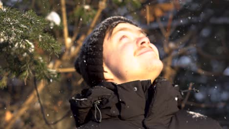 man looking up at snowflakes in winter