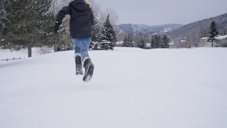 Cámara-Lenta,-Joven-Adolescente-Corriendo-En-Un-Campo-Cubierto-De-Nieve-En-Un-Frío-Día-De-Invierno