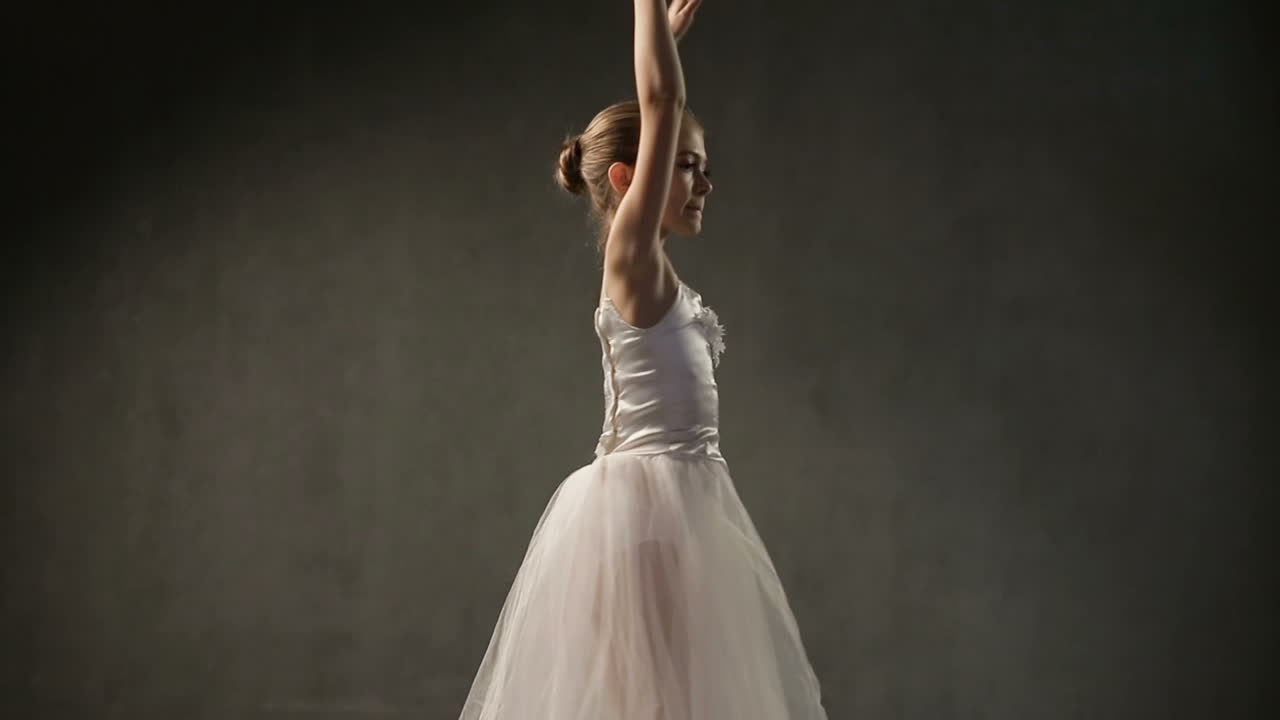 Young Ballet Dancers In Studio. Young ballerina with a clothing for performance dancing in the studio