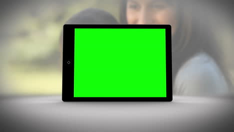 tablet with green screen in front of family outdoors