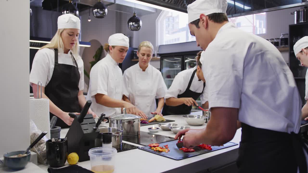chefs multiétnicos en una cocina de un restaurante de pie en un mostrador y preparando comida