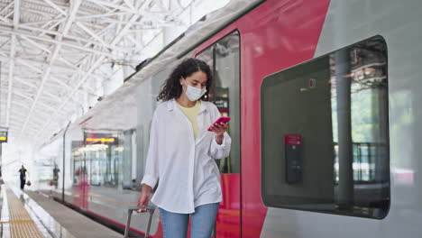 mujer en la estación de tren con una maleta