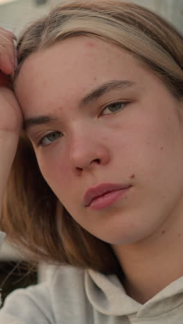la mujer descansa la cabeza sobre su mano en un momento de profunda contemplación, sus ojos parpadean lentamente, su expresión revela introspección y reflexión, con un fondo suave