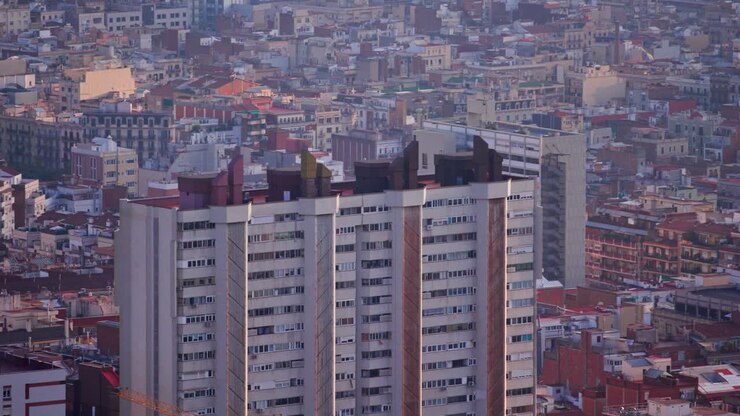 Incrível imagem aérea de drone de um edifício residencial alto em Barcelona, cercado por uma paisagem urbana.