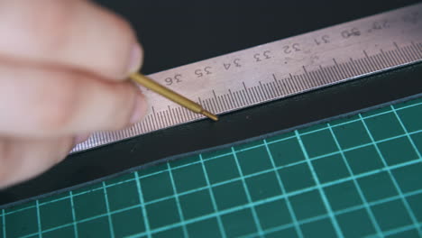 person draws line on black leather fabric with special pen