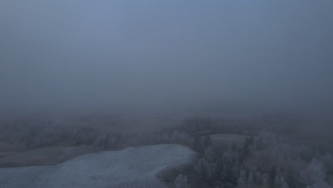 Foggy-arial-view-over-Norwegian-farm-covered-in-fog