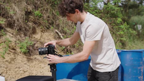 Male-cameraman-attach-digital-camera-with-lens-on-electronic-stabilizer,-Czechia