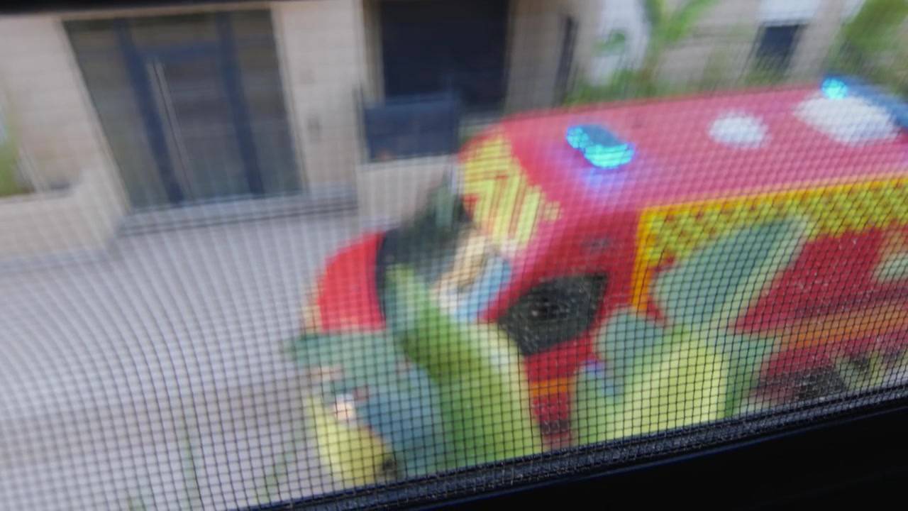 Uklart syn gjennom et vindusnett av et rødt utrykningskjøretøy parkert nedenfor, Côte d'Azur, Frankrike