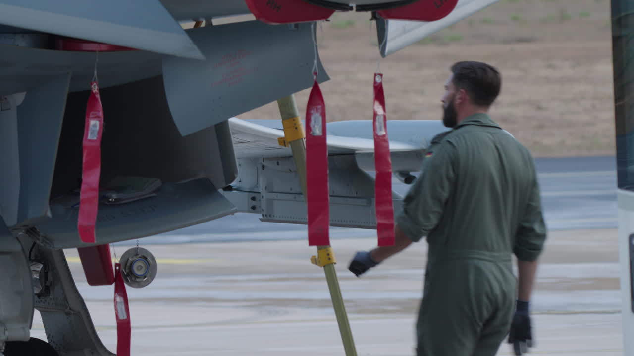 Personale militare al lavoro su un aereo da caccia sul piazzale