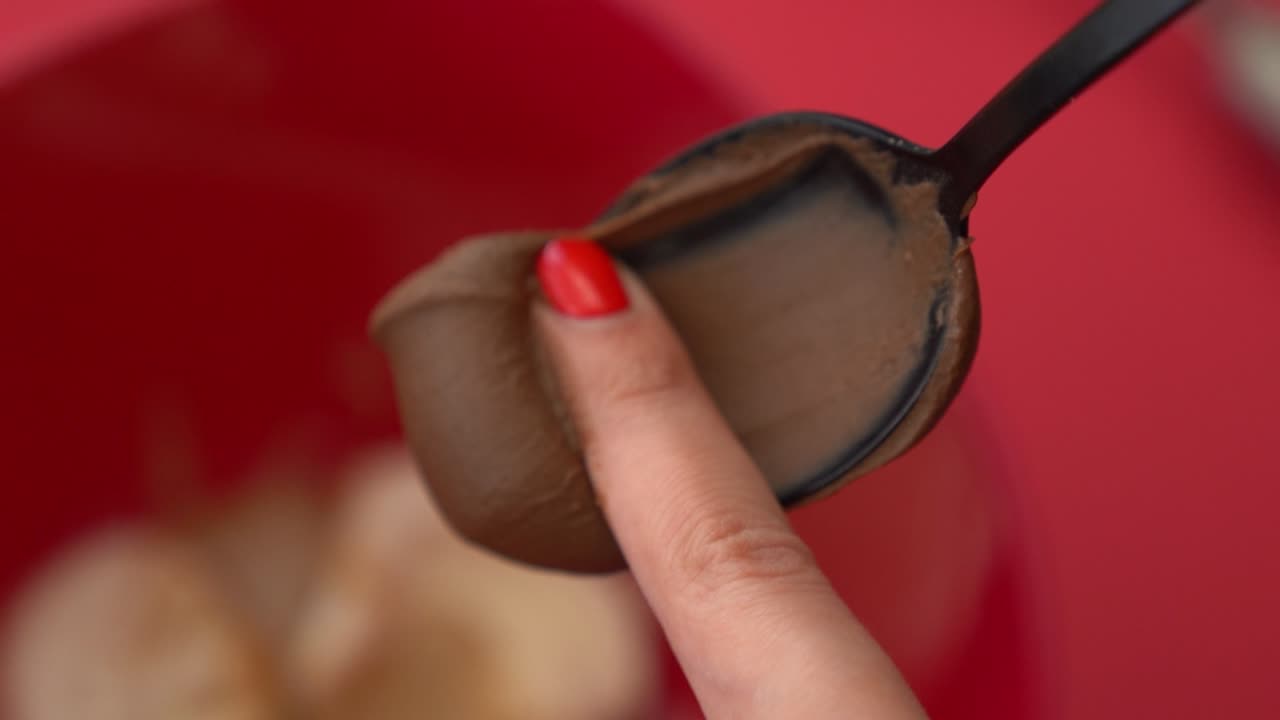 Close-up of adding chocolate spread to a bowl