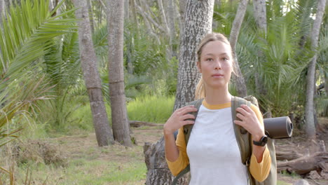 A-young-Caucasian-woman-with-blonde-hair-stands-in-a-forest-setting-with-copy-space