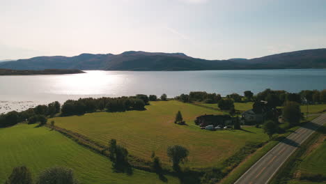 Aguas-Relucientes-Del-Fiordo-De-Skjerstad-Desde-Una-Carretera-Vacía-Cerca-De-Una-Casa-De-Campo-En-Nordland,-Noruega