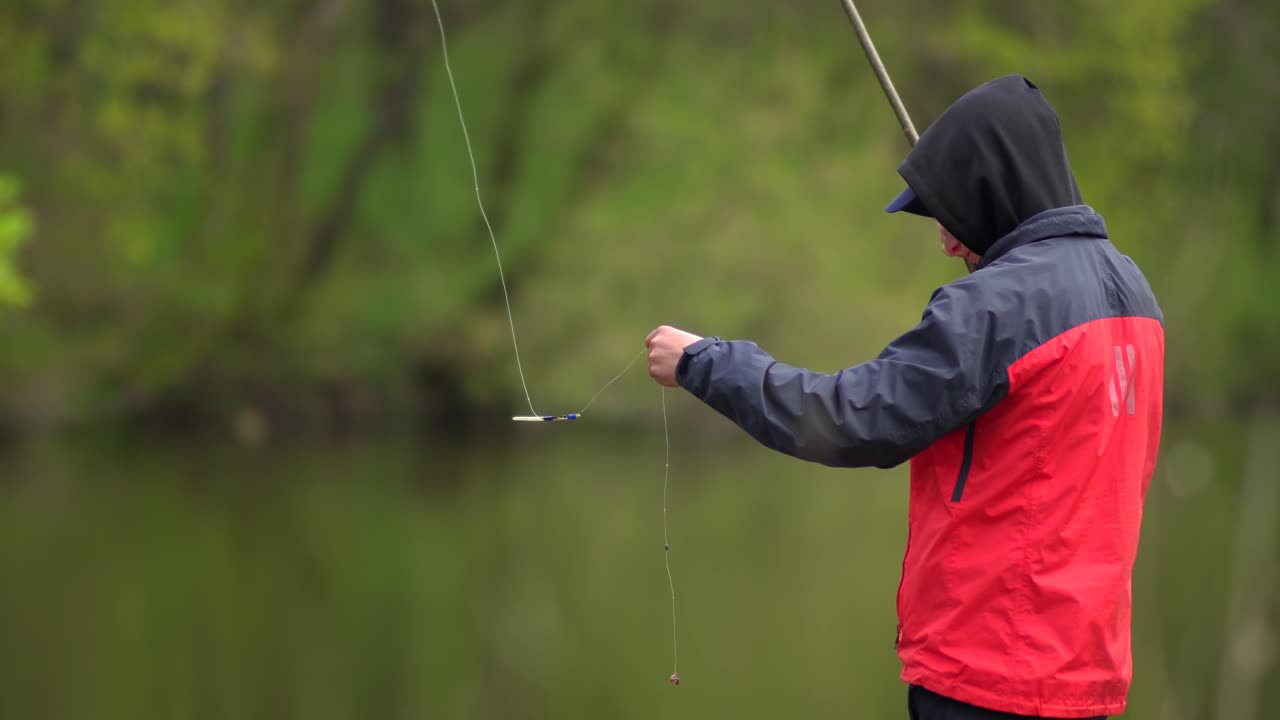 Remaja mengenakan jaket merah memancing dengan joran 02