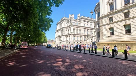 people and vehicles on a sunny london street