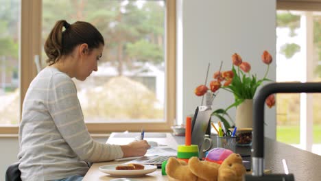 Young-Woman-is-Working-at-Home-on-a-Laptop.focused-woman-wearing-glasses-typing-over-the-keyboard-of-her-laptop-while-sitting-at-home.-concentrated-female-freelancer-working.-remote-work,-self-employment-and-study,-solving-task,-research.