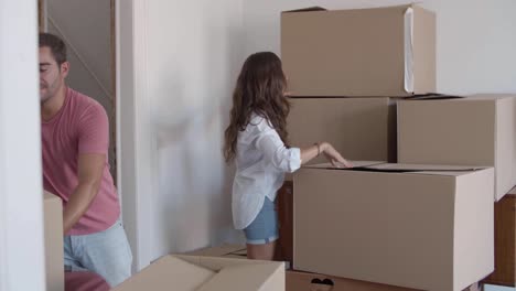 happy woman giving cardboard boxes to boyfriend who putting them on the table