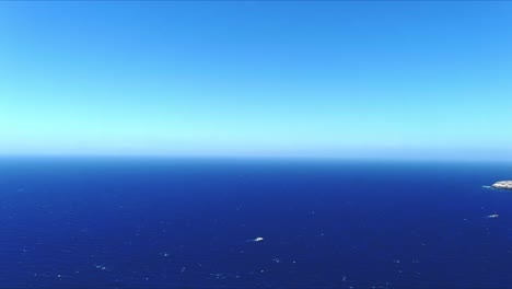 aerial 4k blue sea and sky top view over akrotiri santorini greece horizon push in