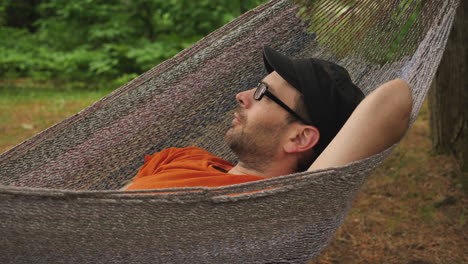 man resting in hammock and blinking