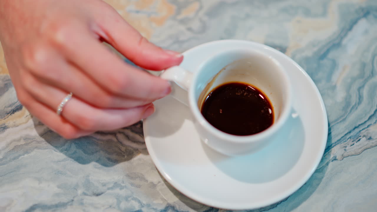 Close up of a white cup of coffee on a marble table