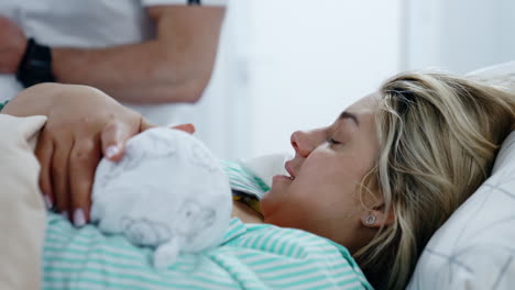 happy new mom is caressing her baby being breastfed. woman and child after the childbirth. close up.