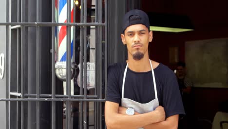 male hairdresser standing with arms crossed at the entrance 4k